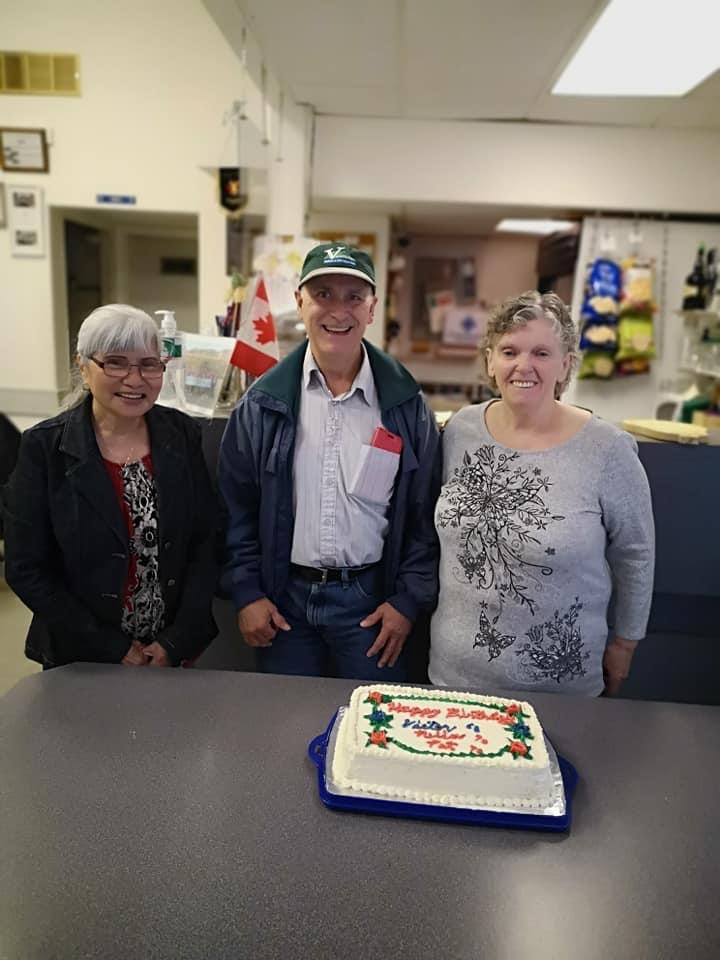 Members gathered around a birthday cake