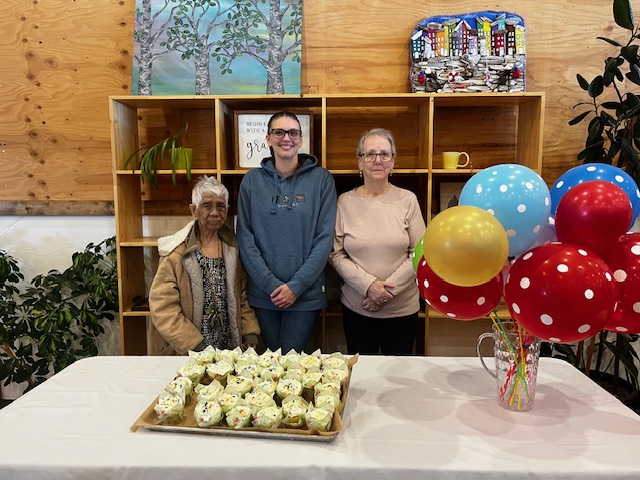 Group gathered around a decorated celebration cake