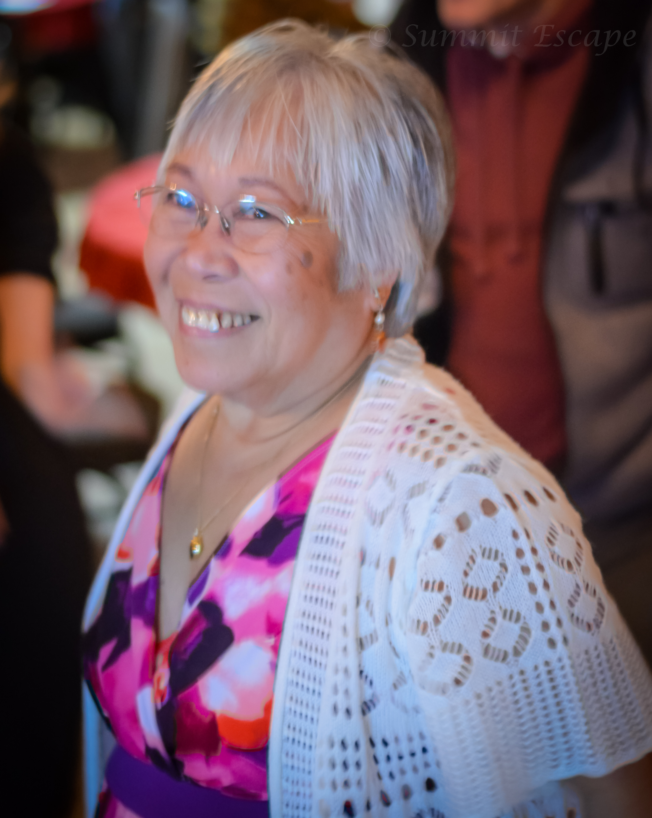 Smiling member wearing a crocheted sweater